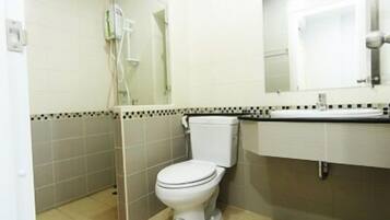 Casa de banho pequena e limpa, com sanita, lavatório e espelho.