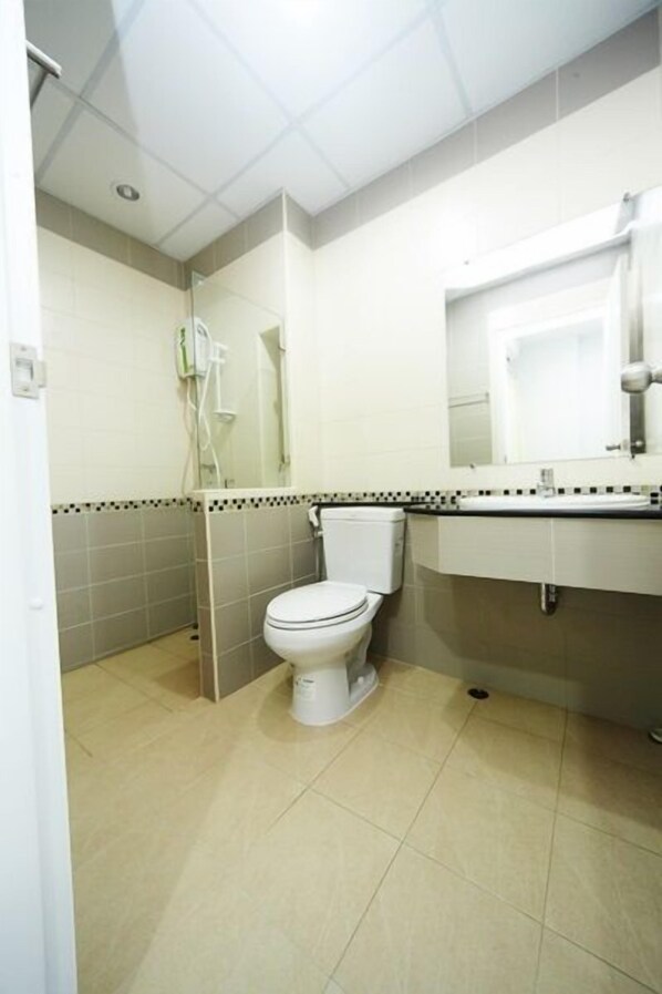 A small, clean bathroom with a toilet, sink, and mirror. - Central place serviced apartment 1 (Chonburi)