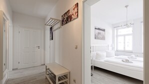 Une chambre à coucher avec un lit, une table de chevet, une fenêtre et une porte.
