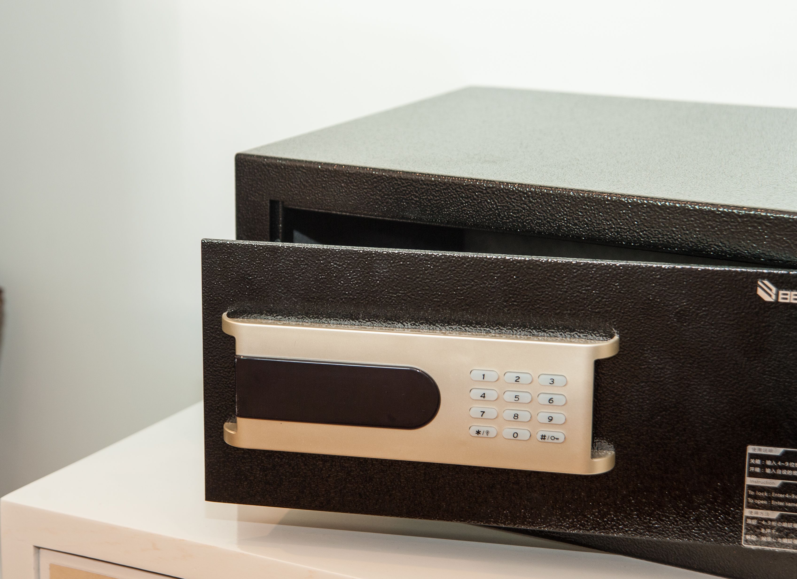 A black and beige fax machine with a keypad and a label with instructions.