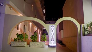 A building entrance with a sign reading "ORPHEUS STUDIOS" and a pathway leading to the interior. - Orpheus Studios (Kos)