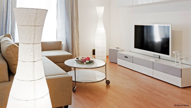 Una sala de estar moderna con un sofá, una mesa de centro, un televisor y un mueble aparador.