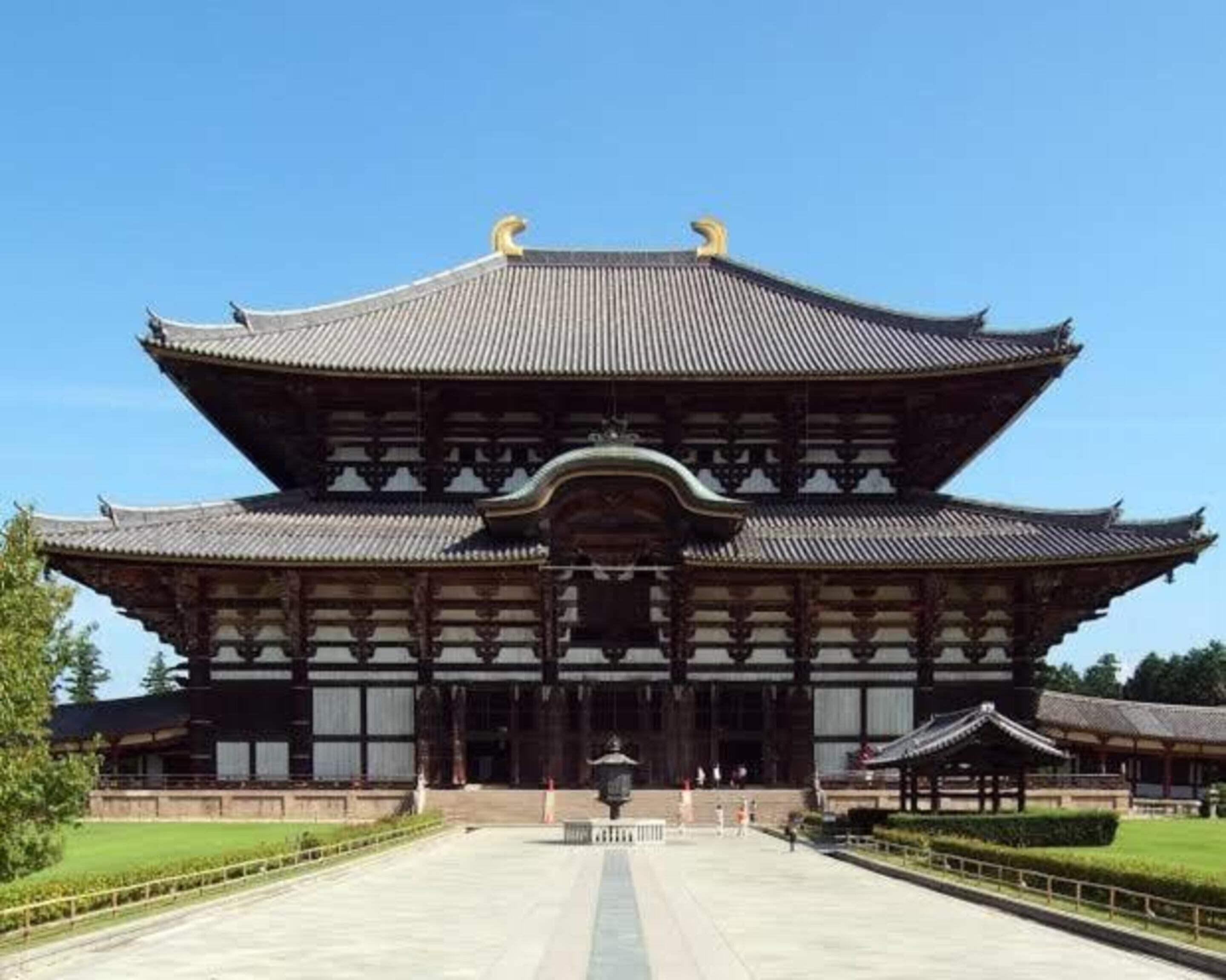 A traditional Japanese building with a symmetrical roof and wooden structure.