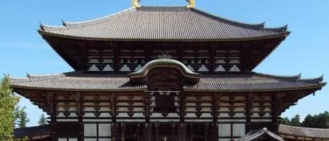 A traditional Japanese building with a symmetrical roof and wooden structure.