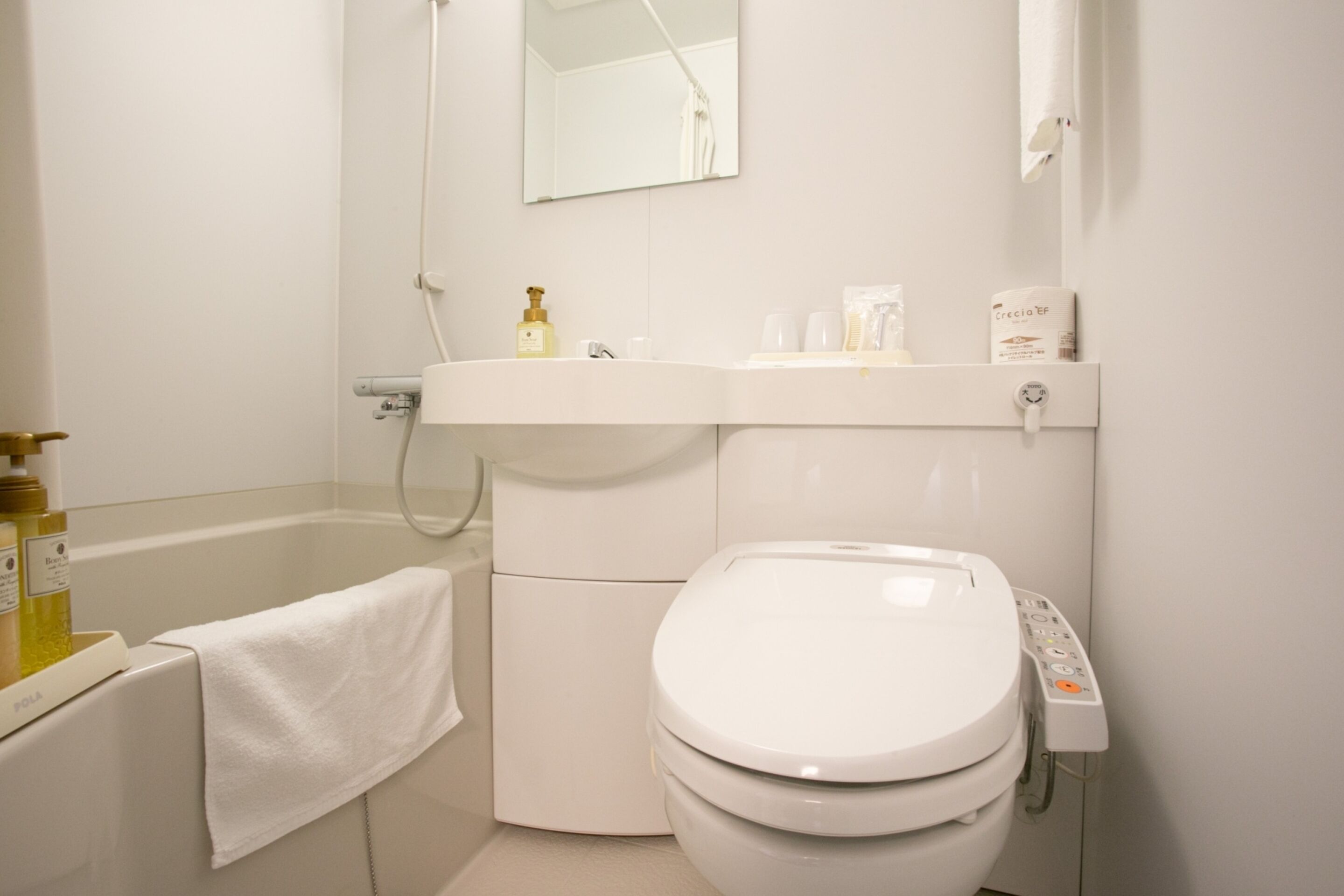 Un baño moderno con inodoro blanco, lavamanos y bañera.