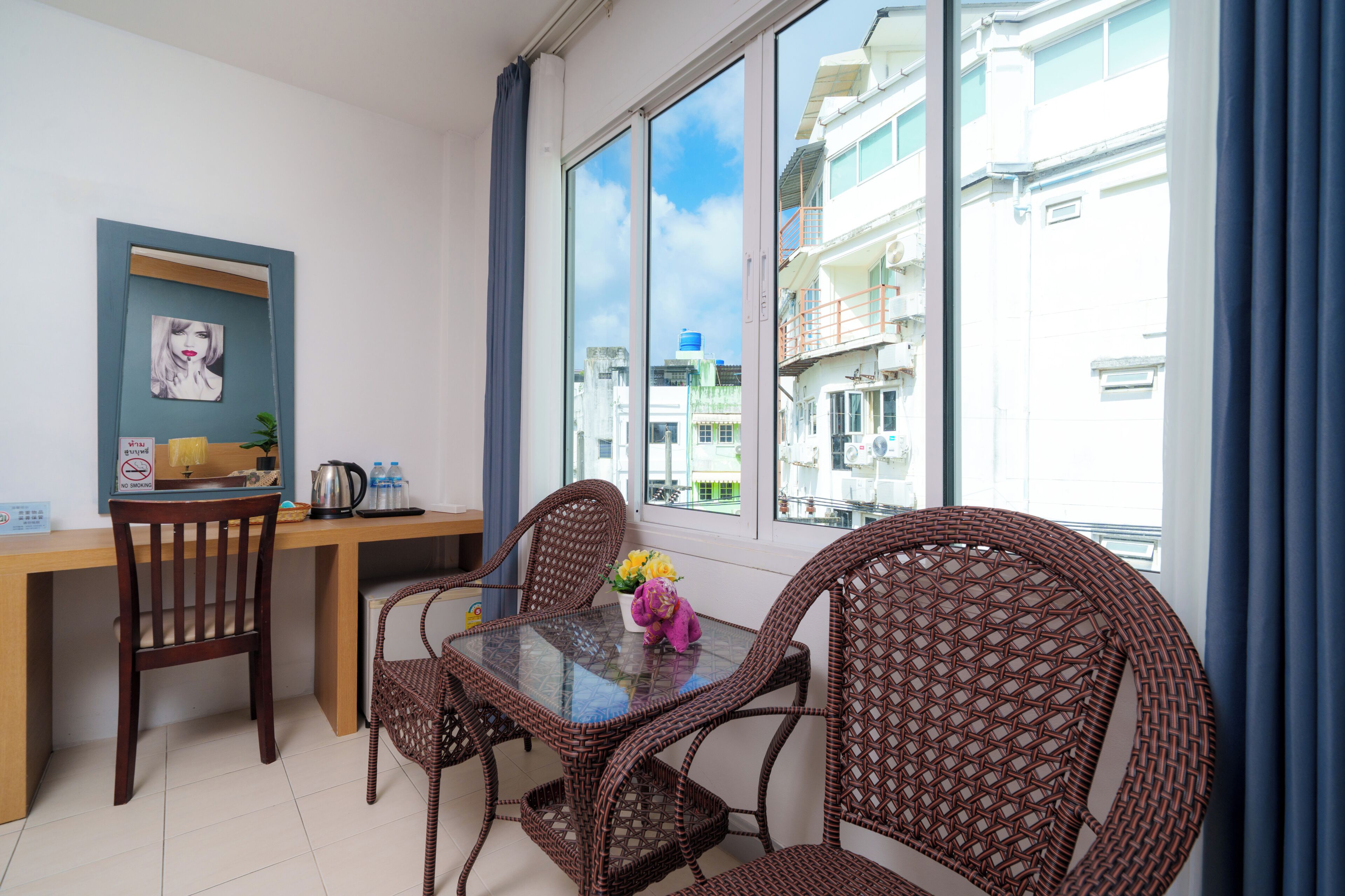 Ein Balkon mit Korbmöbeln, einem Tisch und einem Stuhl.