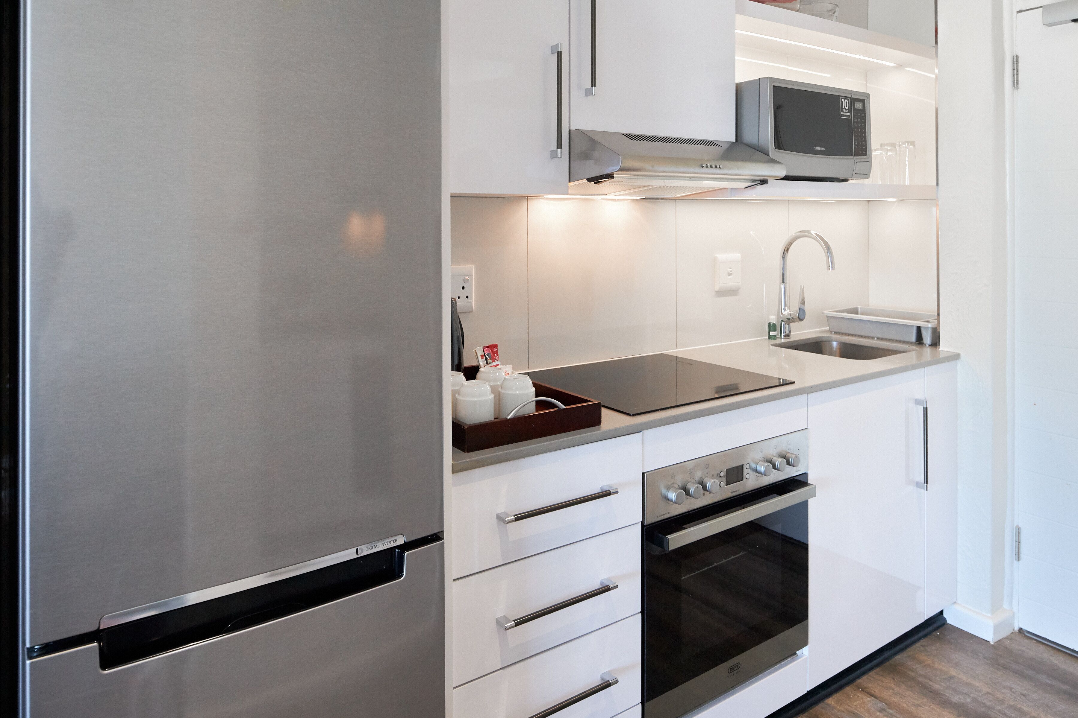 A modern kitchen with stainless steel appliances, a microwave, a sink, and a built-in oven.