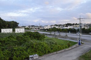 A residential area with houses, a road, and greenery. - The White Reef (Uruma)