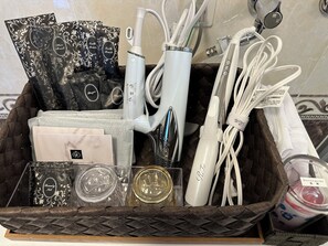 A basket containing various toiletries and personal care items, including a hairbrush, toothbrushes, and a bottle of detergent. - The White Reef (Uruma)