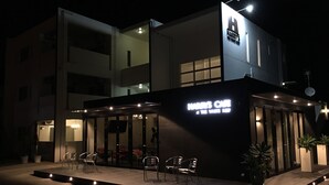 A modern building with a sign reading "Harry's Cafe The White Room". - The White Reef (Uruma)