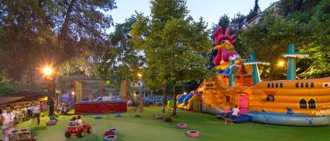 An outdoor playground with inflatable structures and tire obstacles.