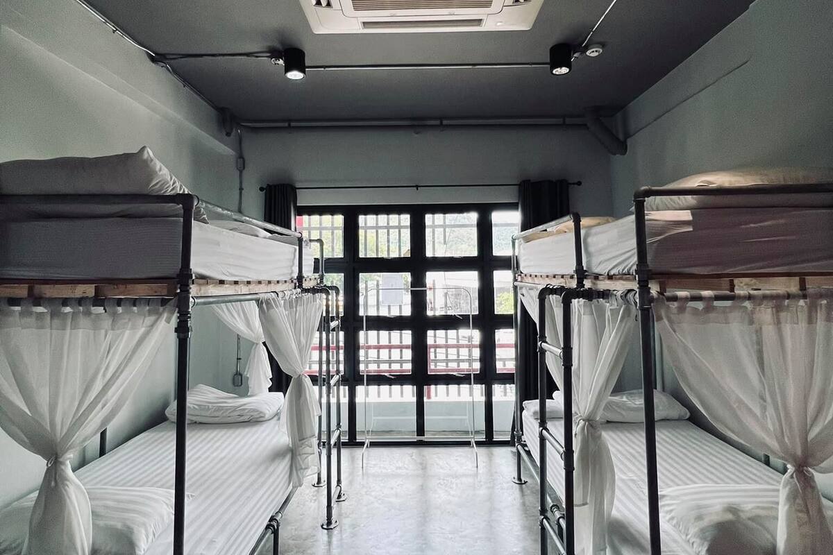A room with bunk beds, a ceiling fan, and a window with a view.