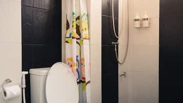 A modern bathroom with a toilet, shower, and a curtain with animal prints.