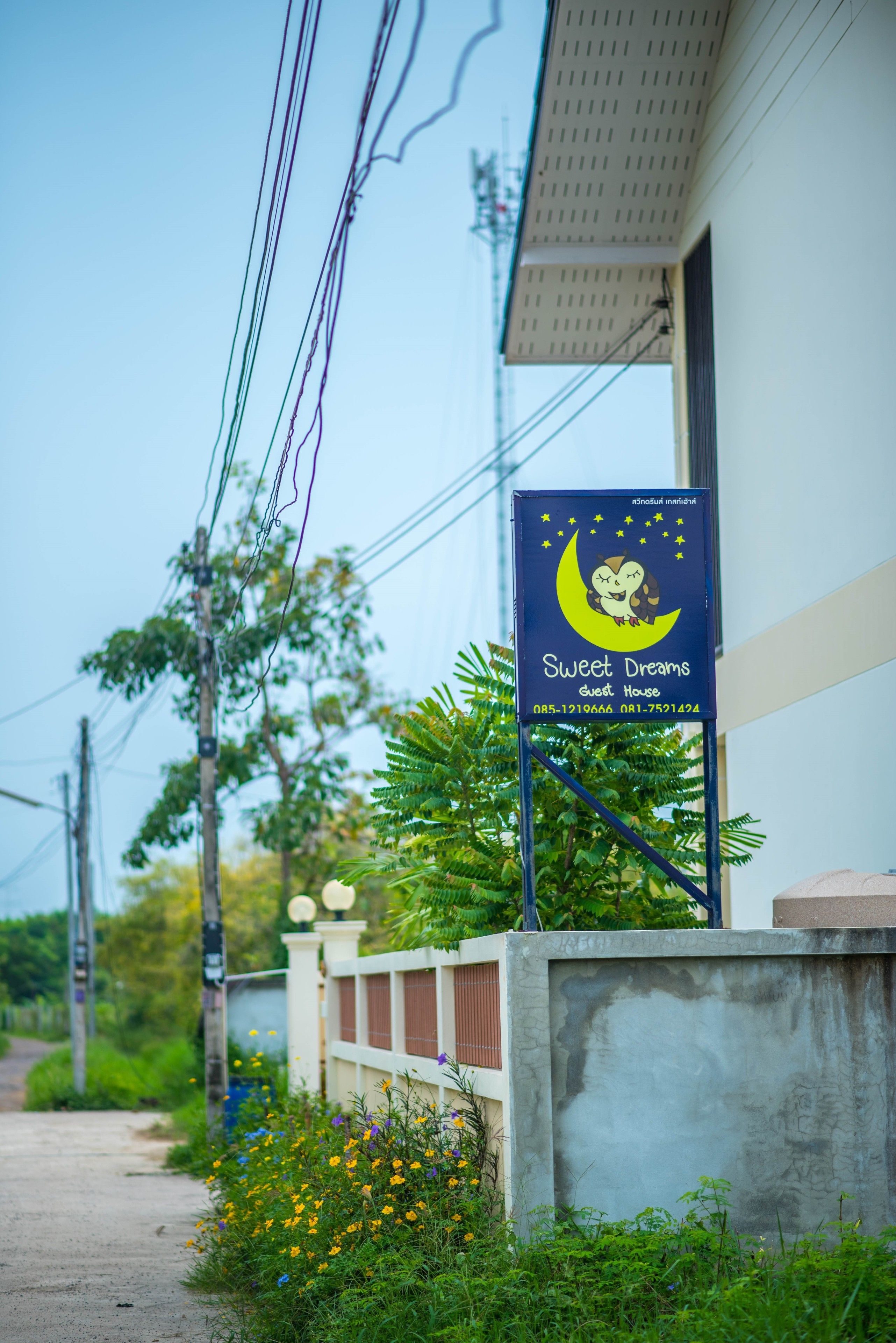 Un cartel anunciando 'Sweet Dreams Guest House' con números de contacto.