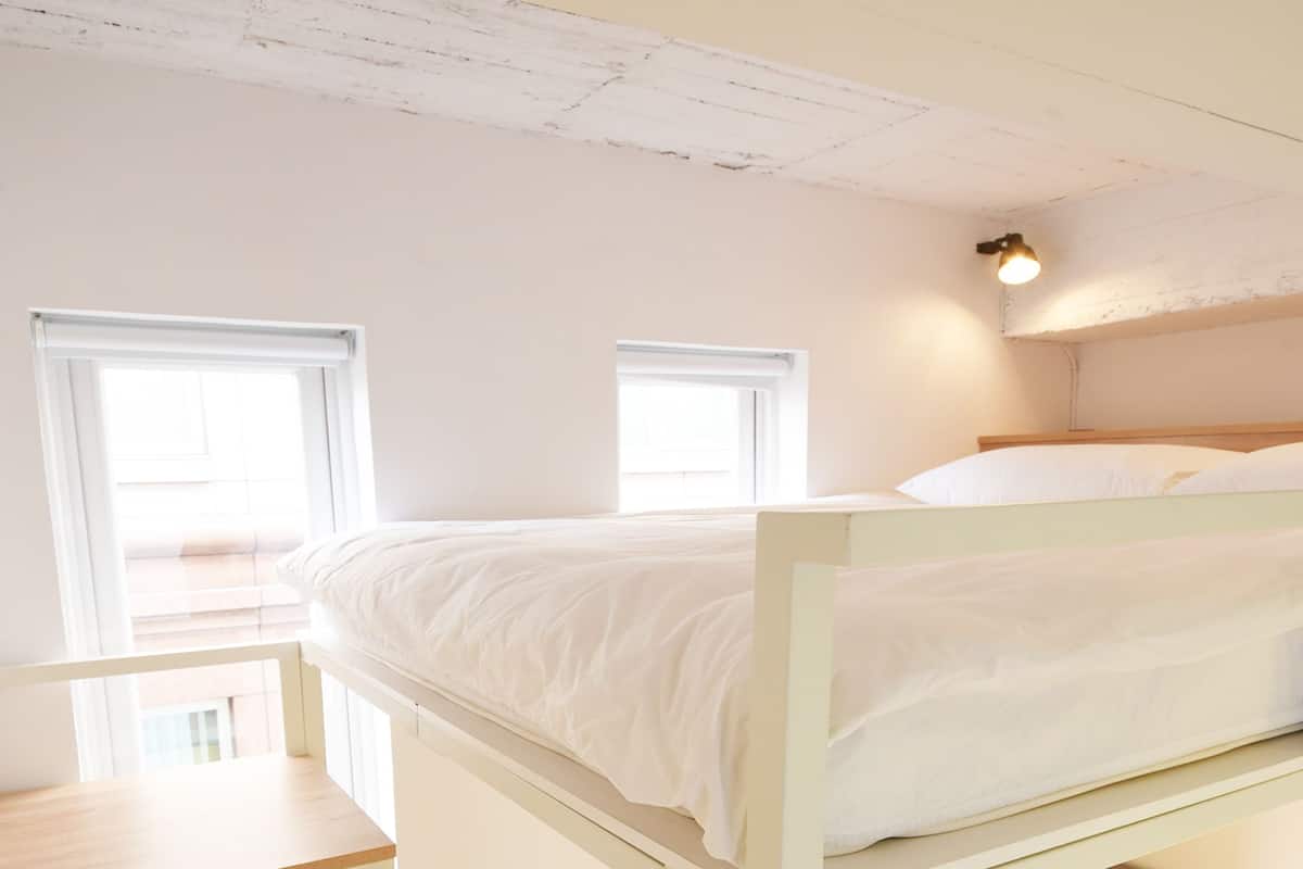 Un lit superposé avec un bureau et un canapé en dessous.