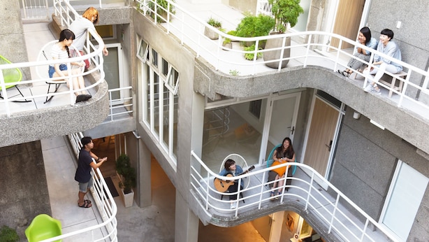 A multi-level building with balconies, seating areas, and potted plants. - OwlStay Flip Flop Hostel Garden (Taipei)