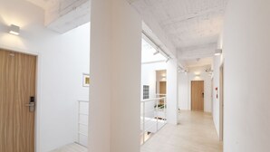 A modern interior with a wooden door, white walls, and a light wooden floor. - OwlStay Flip Flop Hostel Garden (Taipei)