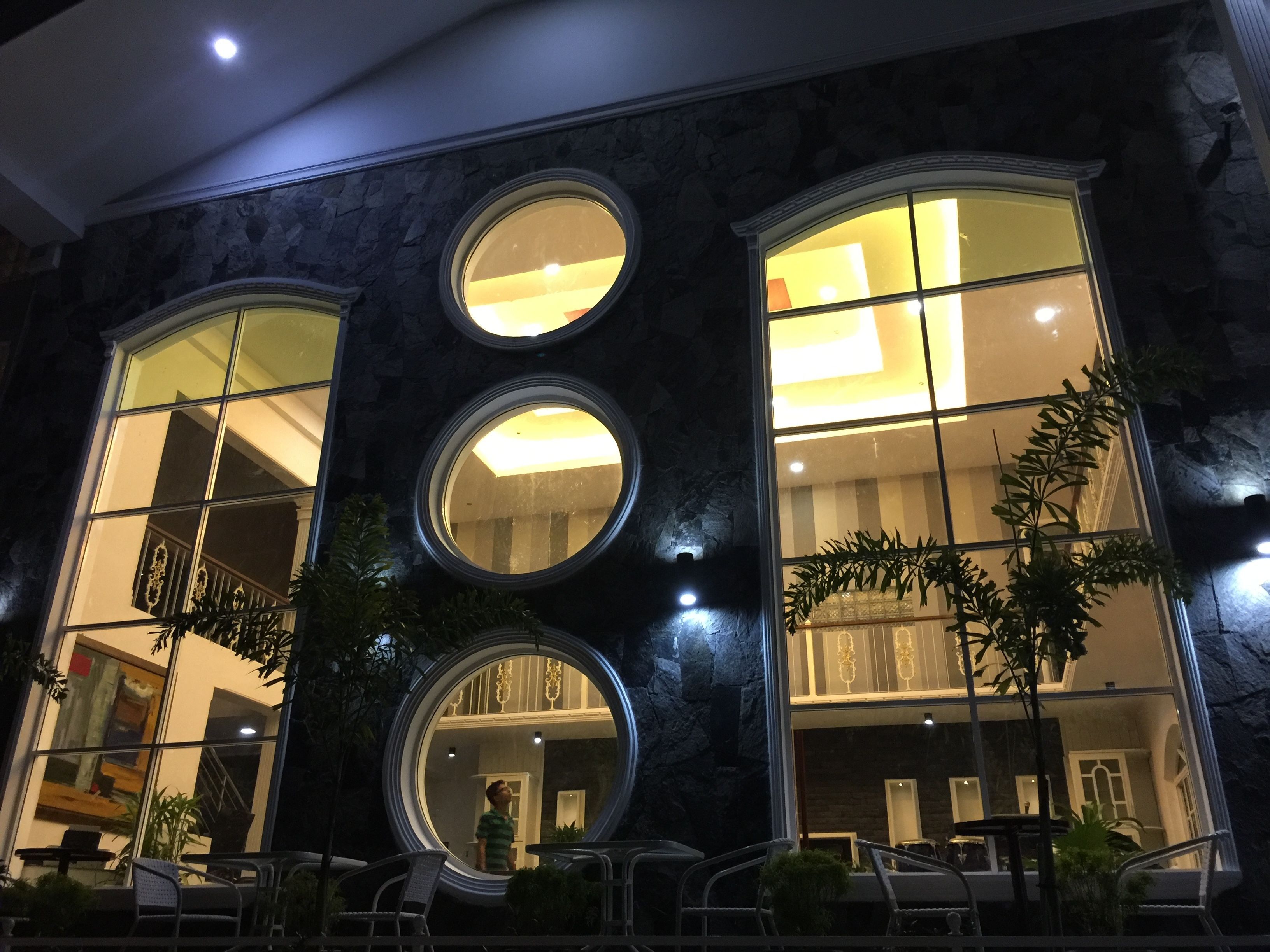 A building with three large circular windows and a staircase leading to an upper level.