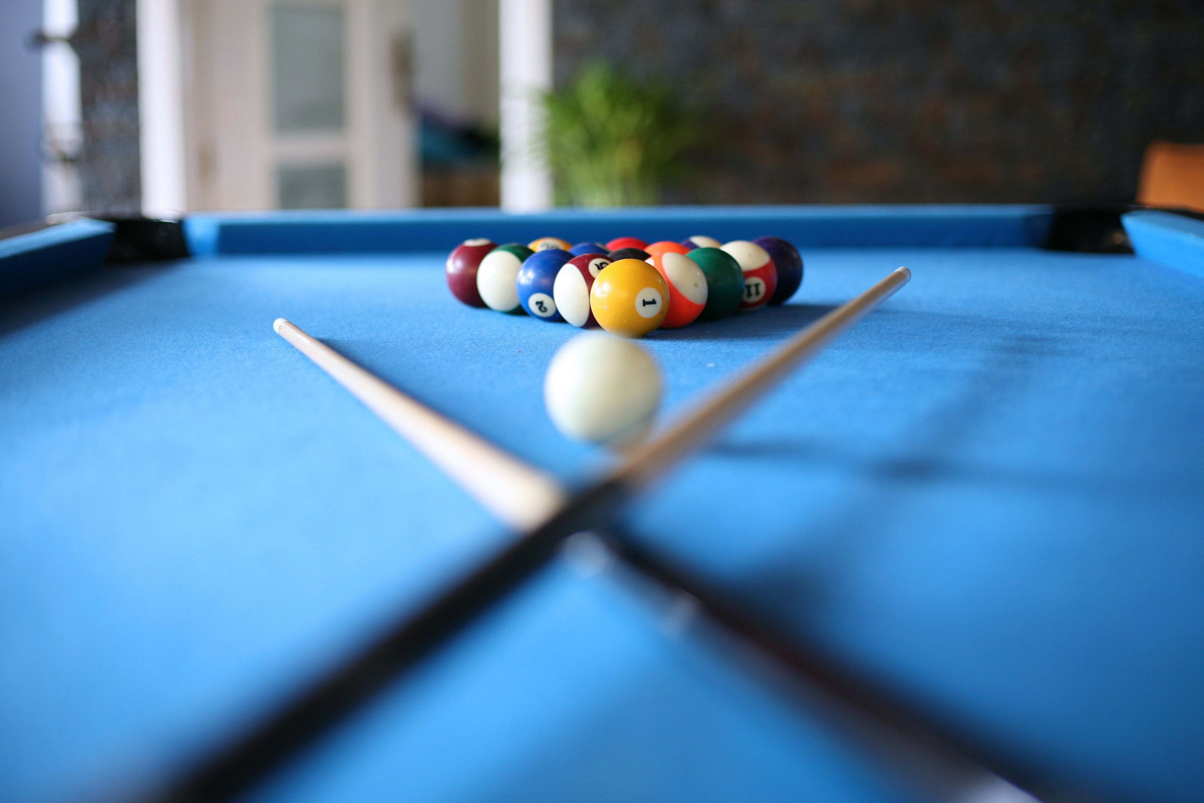 A pool table with a white cue ball and colorful numbered balls.