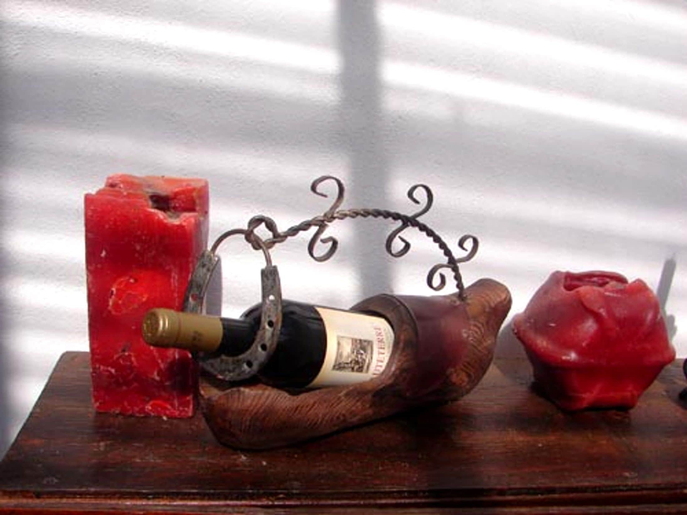 Een fles wijn in een houten spaarvarken op een houten ondergrond.