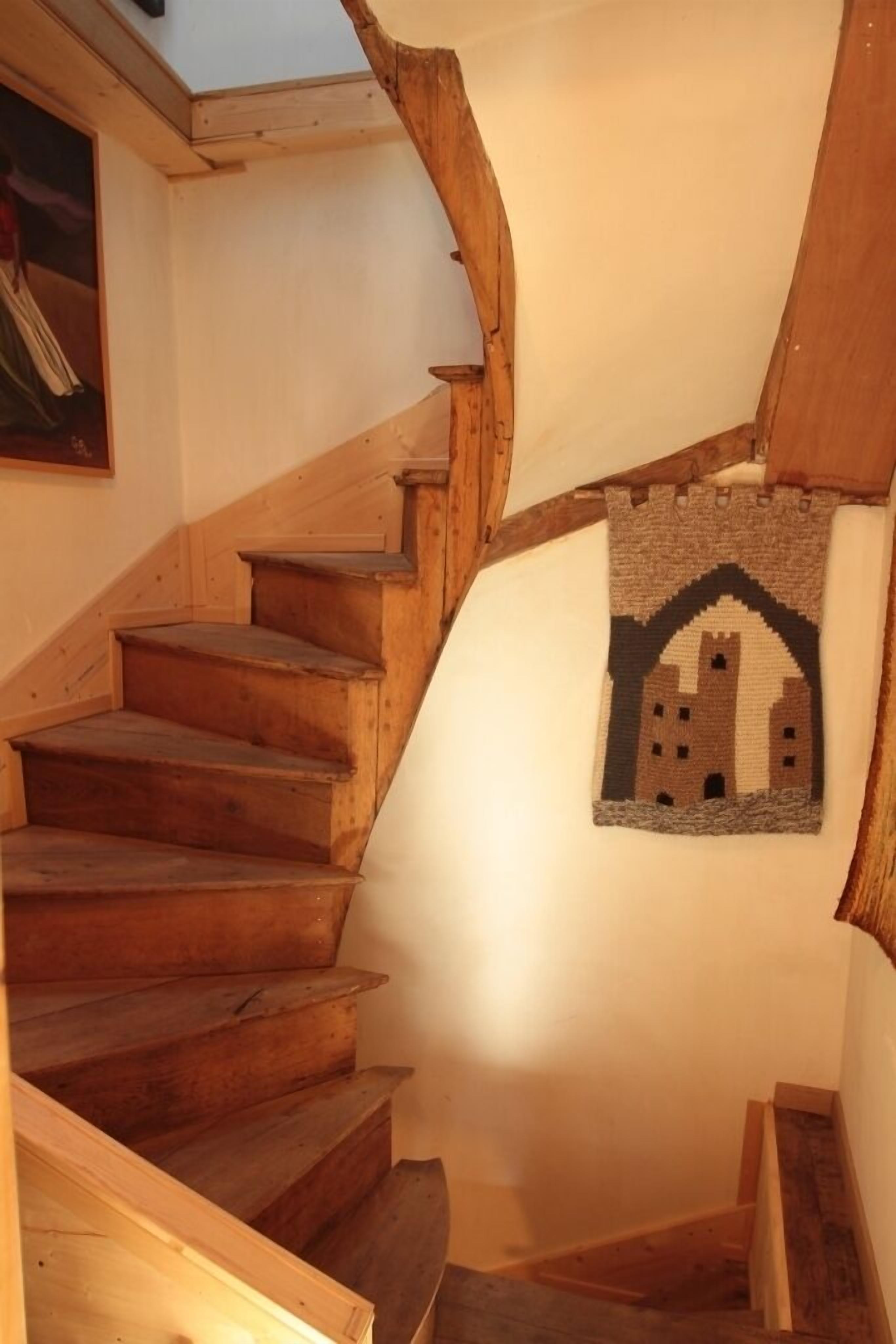 Een houten trap met een wanddecoratie in kasteelstijl.
