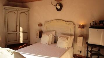 Un dormitorio con cama, lámparas de noche, cómoda y reloj de pared.