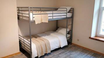 A bunk bed room with a window on the right side.