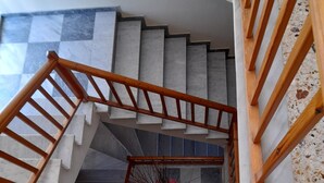 A wooden staircase with a checkered floor pattern leading to a landing. - Phaethon Hotel (Kos)