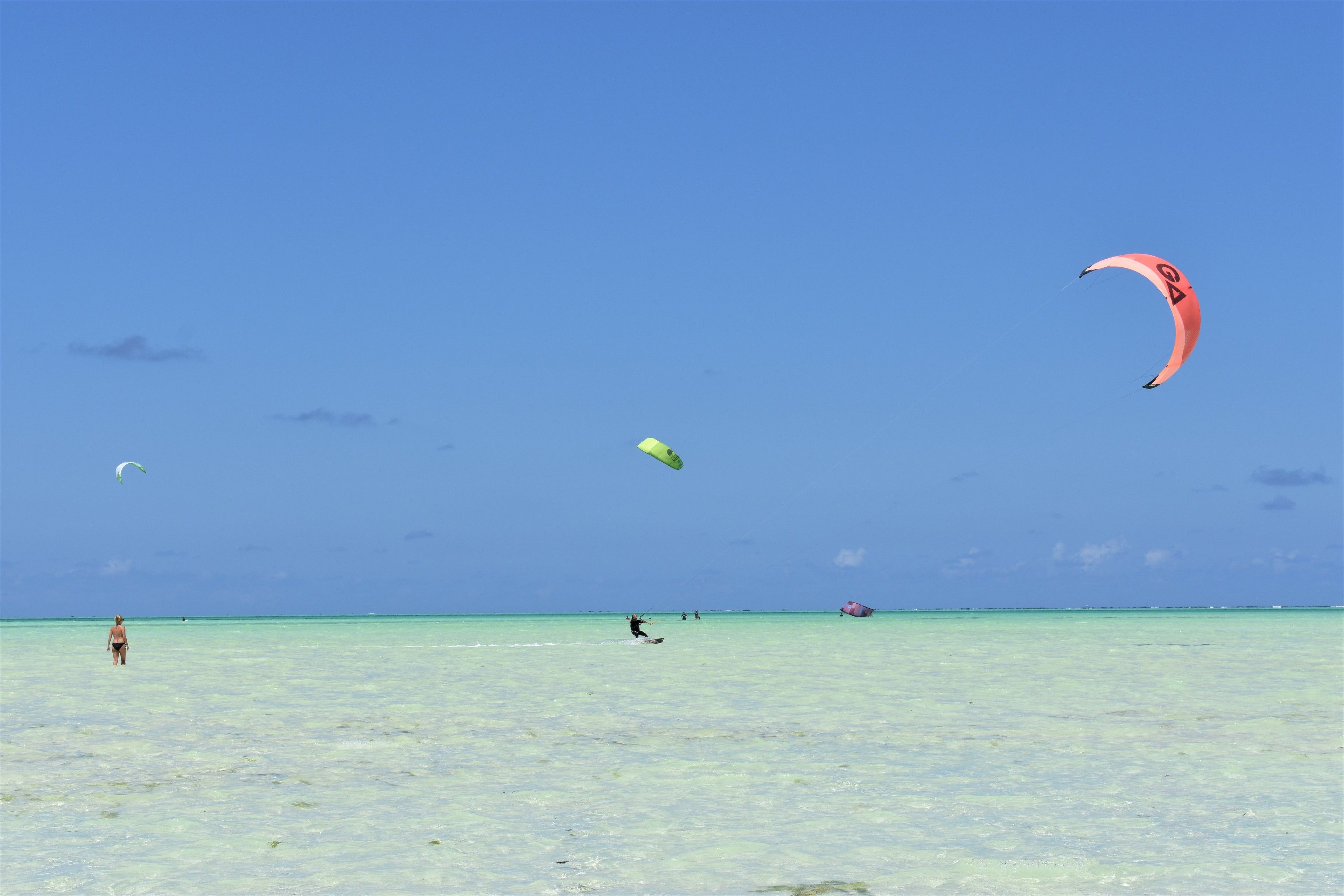 A beach with clear turquoise water and a few people.