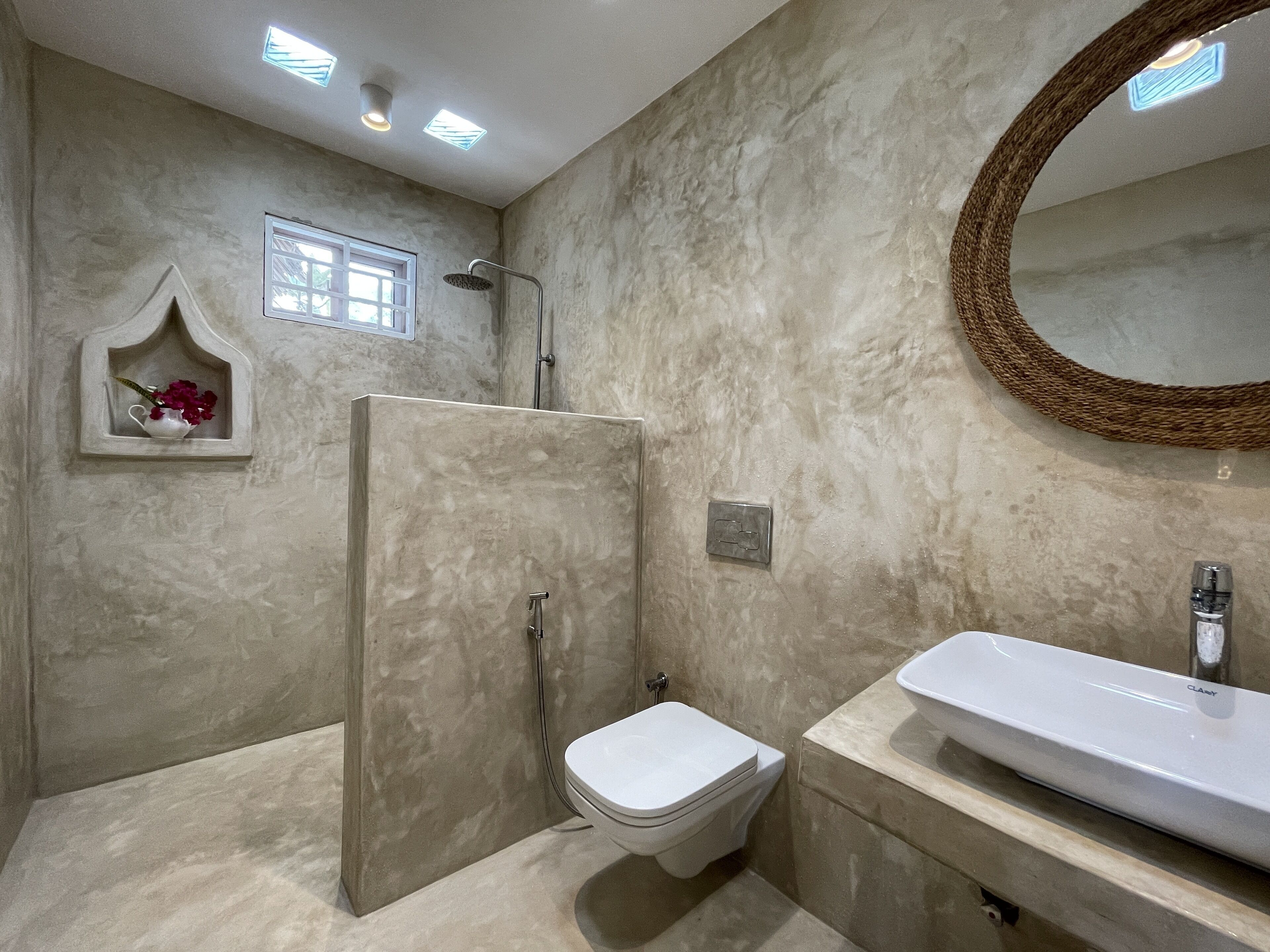 A bathroom with a walk-in shower, a toilet, and a sink.