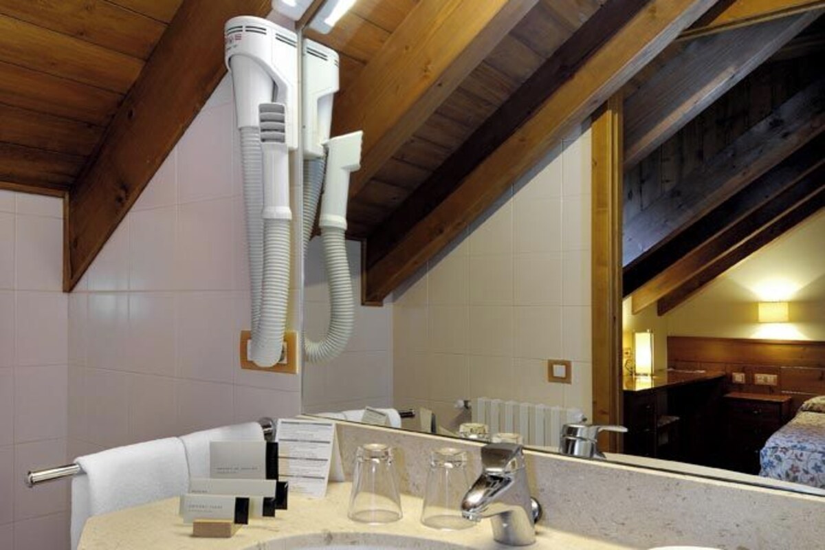 A bathroom with a large sink, a mirror, and a ceiling fan.