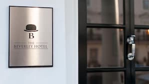 Un letrero de hotel con un símbolo de sombrero y el nombre "The Beverley Hotel".