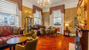 A room with a sofa, chairs, a table, a chandelier, and a mirror. - Kilmorey Arms Hotel (Newry)