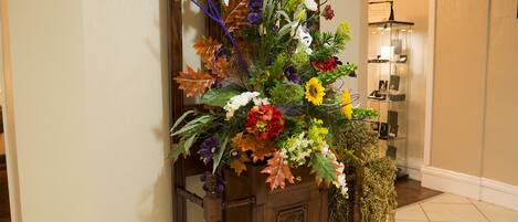 A wooden cabinet with a floral arrangement.