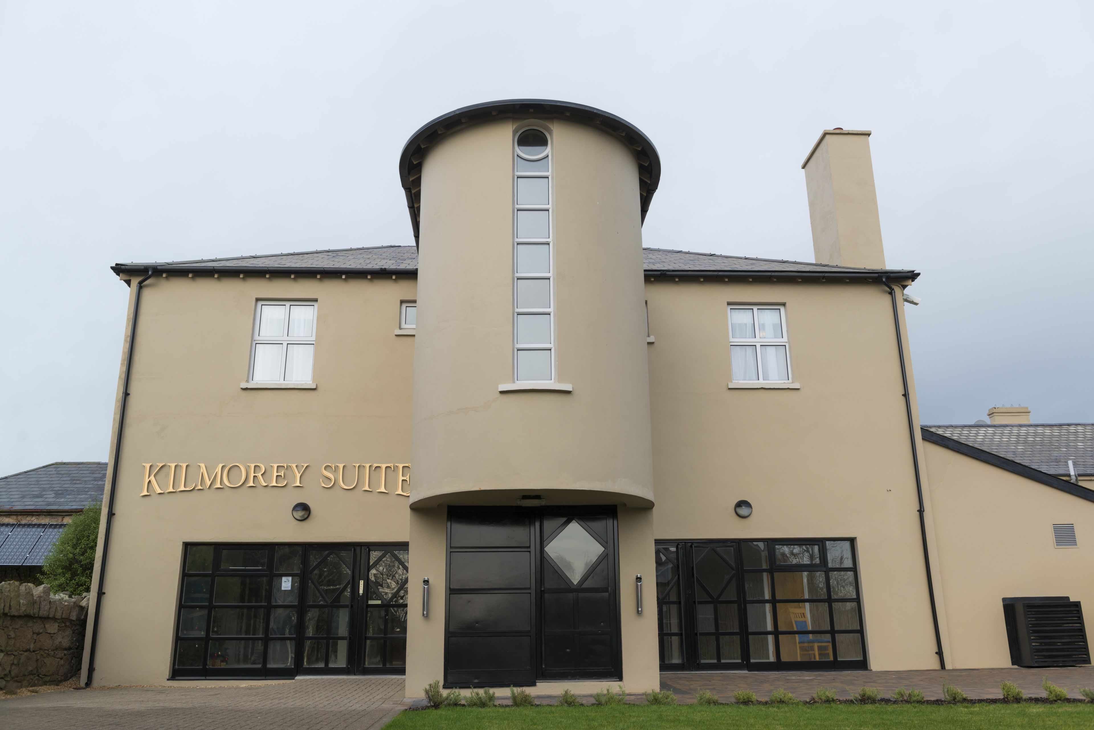 A building with a curved facade, a central tower, and a sign reading "Kilmorey Suite".