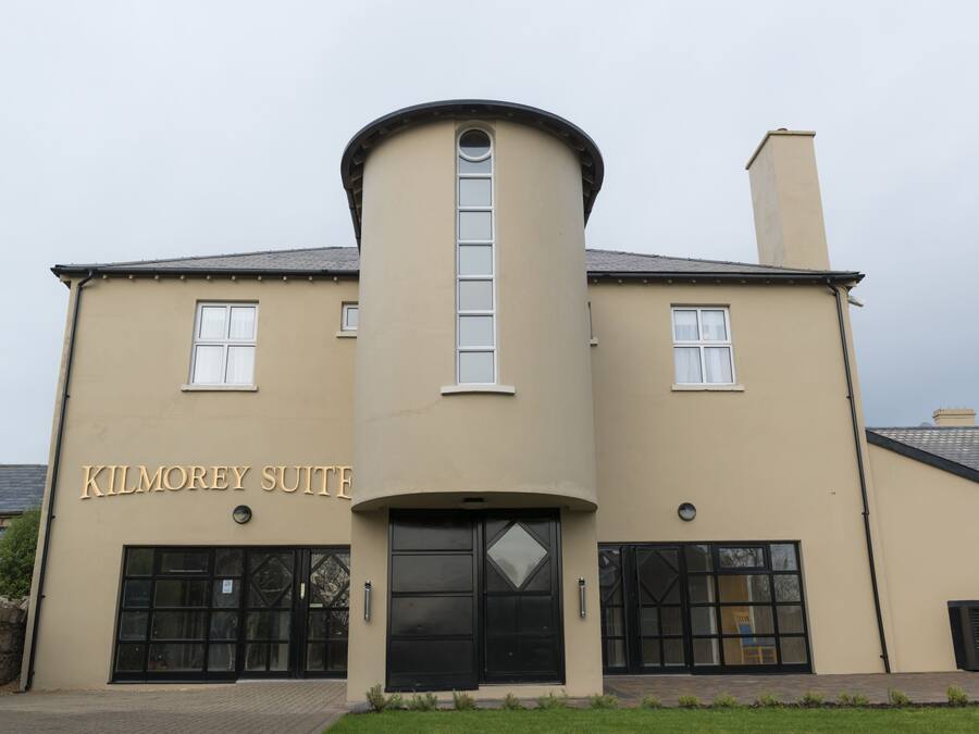 A building with a curved facade, a central tower, and a sign reading "Kilmorey Suite".
