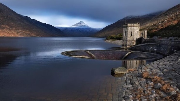 A serene lake with a mountain in the background, a stone structure, and a clear sky. - Kilmorey Arms Hotel (Newry)