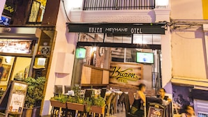 Un hôtel avec une enseigne indiquant « HÔTEL KUZEM » et une entrée bien visible.