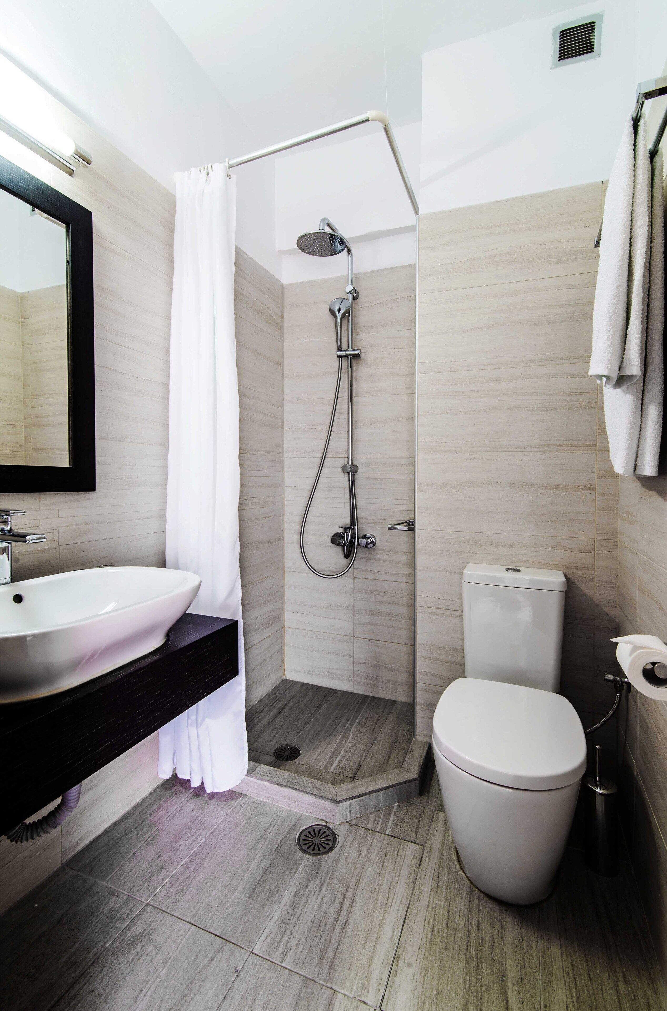 A modern bathroom with a shower, toilet, and sink.