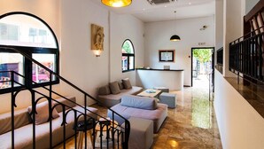 Un intérieur moderne comprenant un escalier, un espace salon et un comptoir d’accueil.
