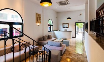 A modern interior with a staircase, seating area, and a reception desk.