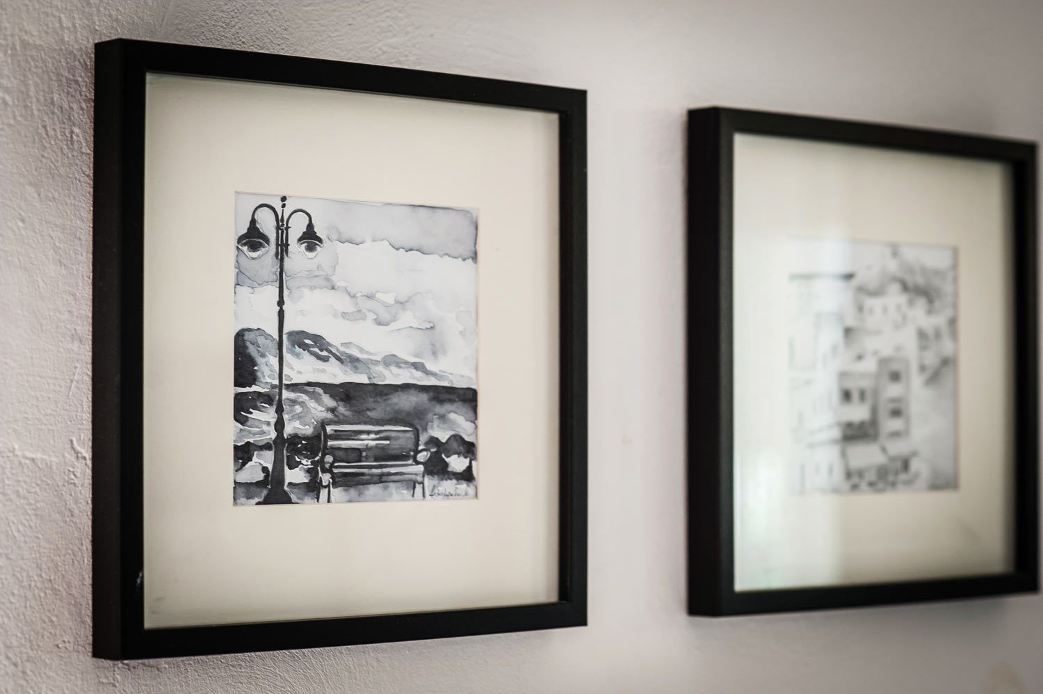Two framed artworks on a wall.