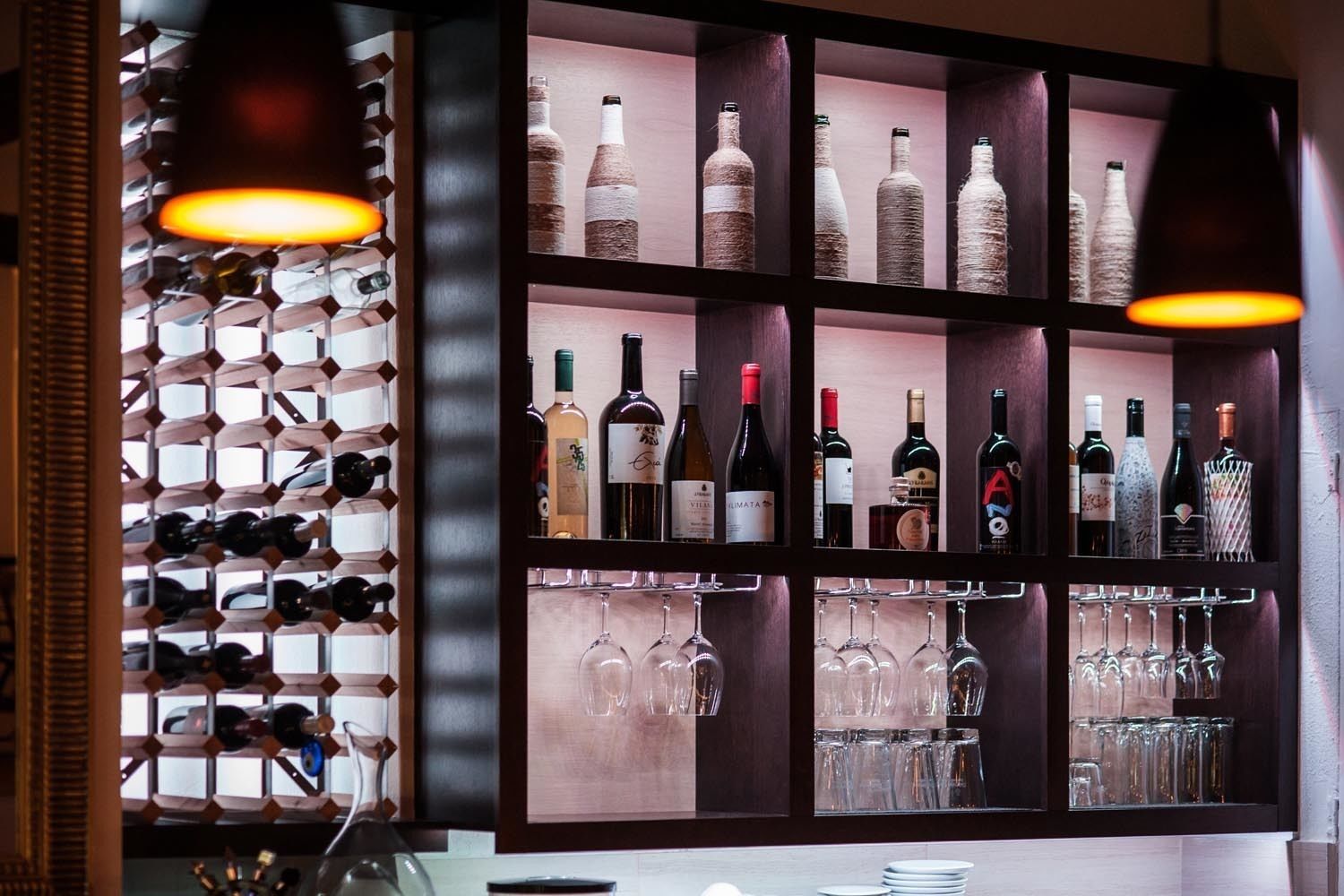 A wine rack with bottles and glasses.