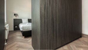 Une chambre à coucher moderne avec un lit, une table de chevet et une armoire.