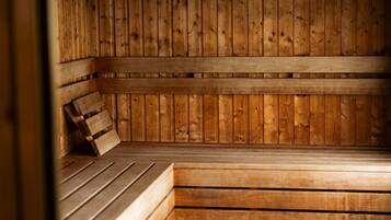Una sauna con bancos y paredes de madera, que presenta un techo inclinado y un banco con respaldo.