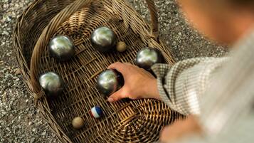 A wicker basket containing metallic balls and a small ball with a flag design.
