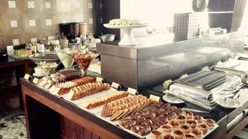 A buffet with various desserts and food items.