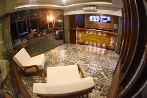A modern lobby with a patterned floor, a reception desk, and a seating area with two lounge chairs.