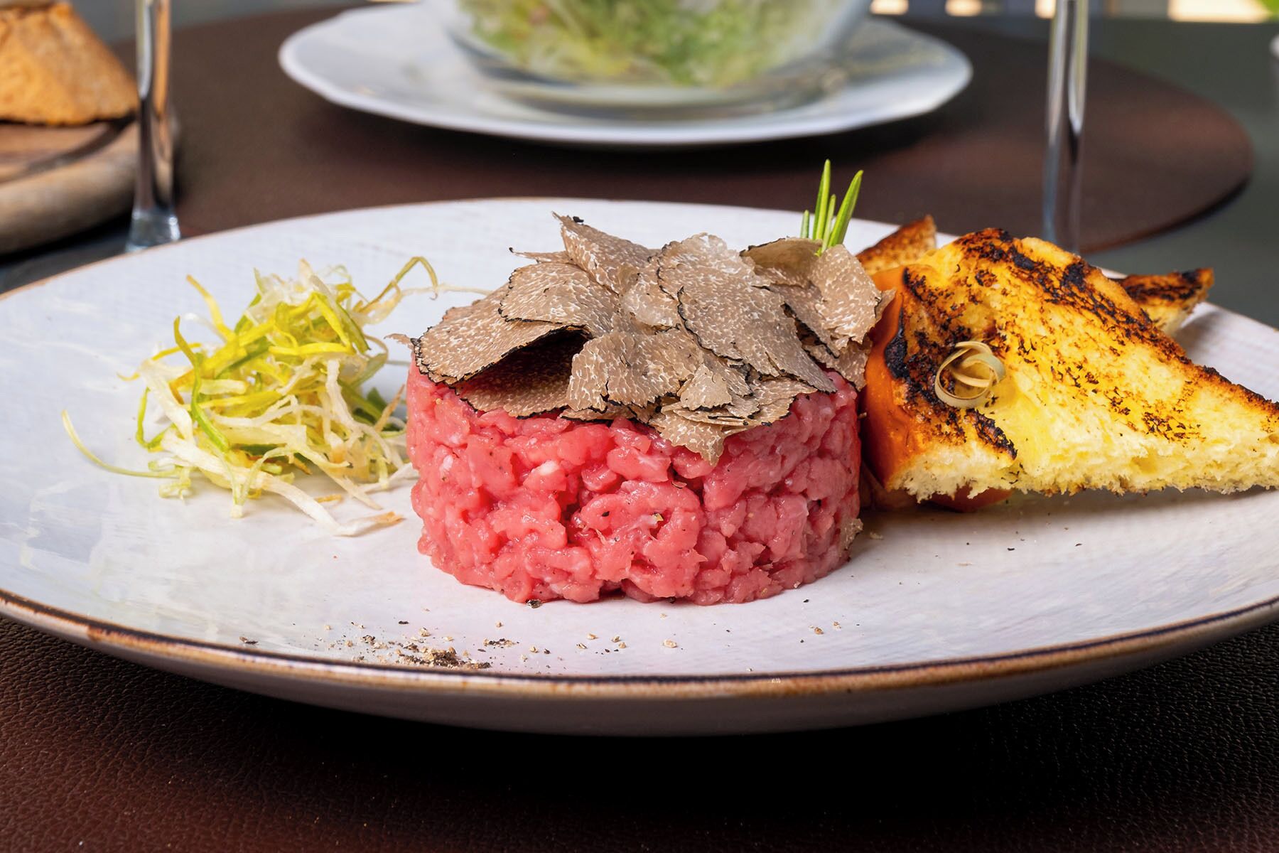 A plate with a meat dish, a side of shredded vegetables, and a grilled item.