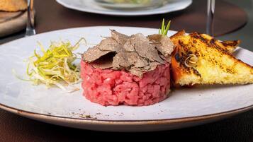 A plate with a meat dish, a side of shredded vegetables, and a grilled item.